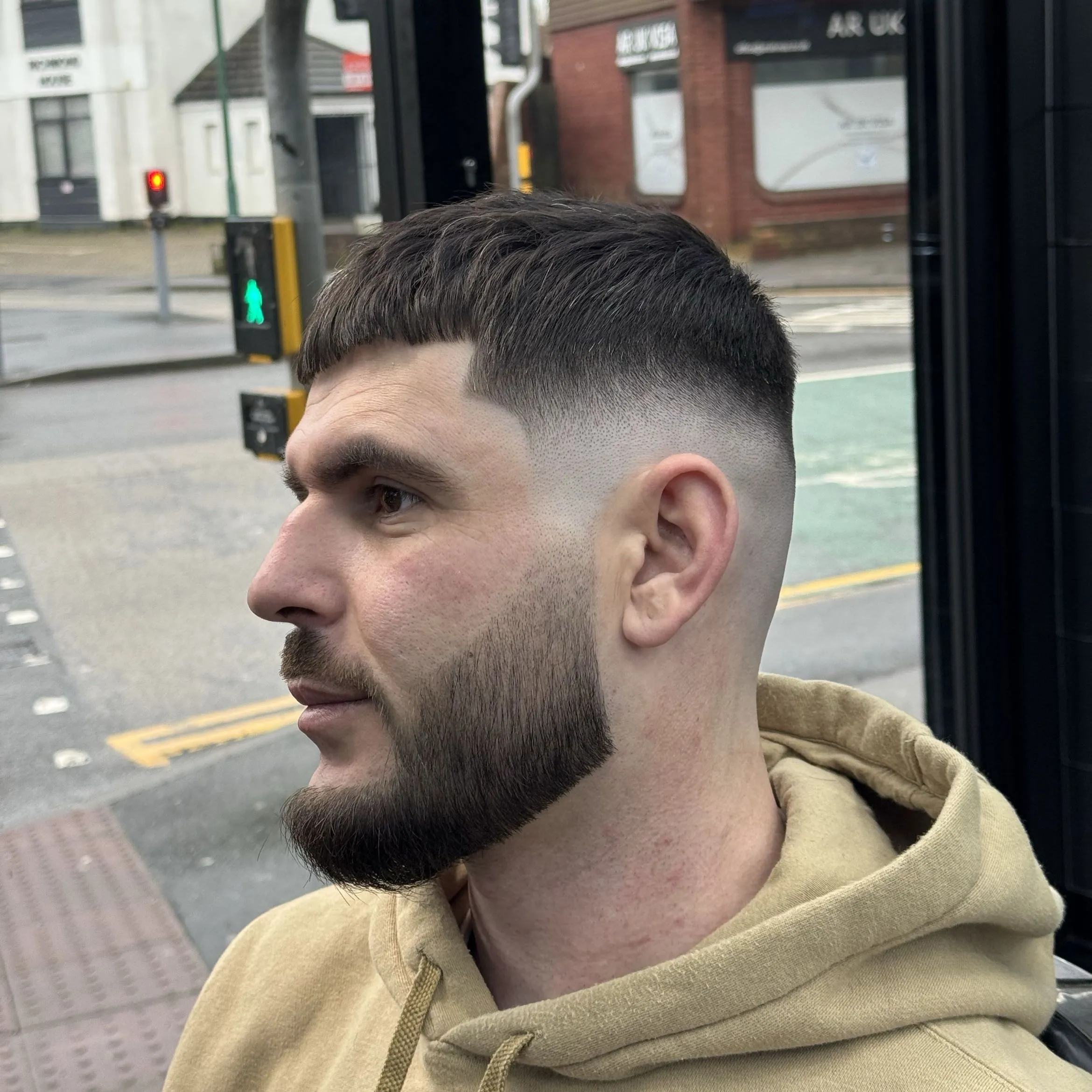 A skin fade and full beard, shaped and lined