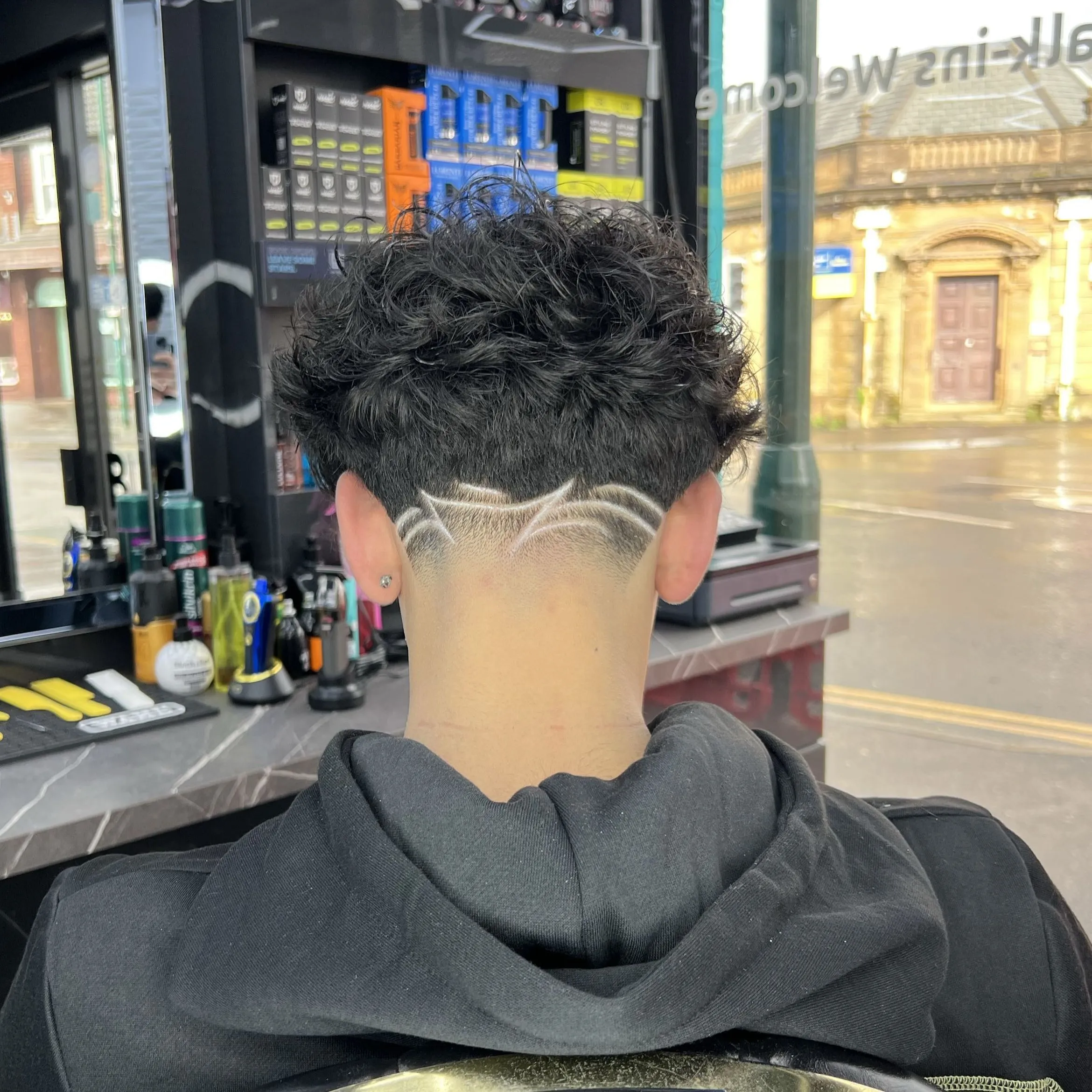 A freestyle line design cut into a fade, the shopfront behind