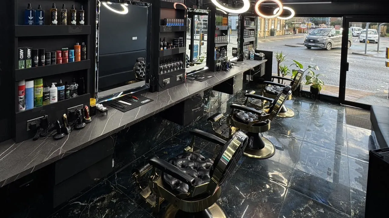 Inside Millionhair: black marble counters, gold and black barber chairs and ring lights, looking out to Charminster Road